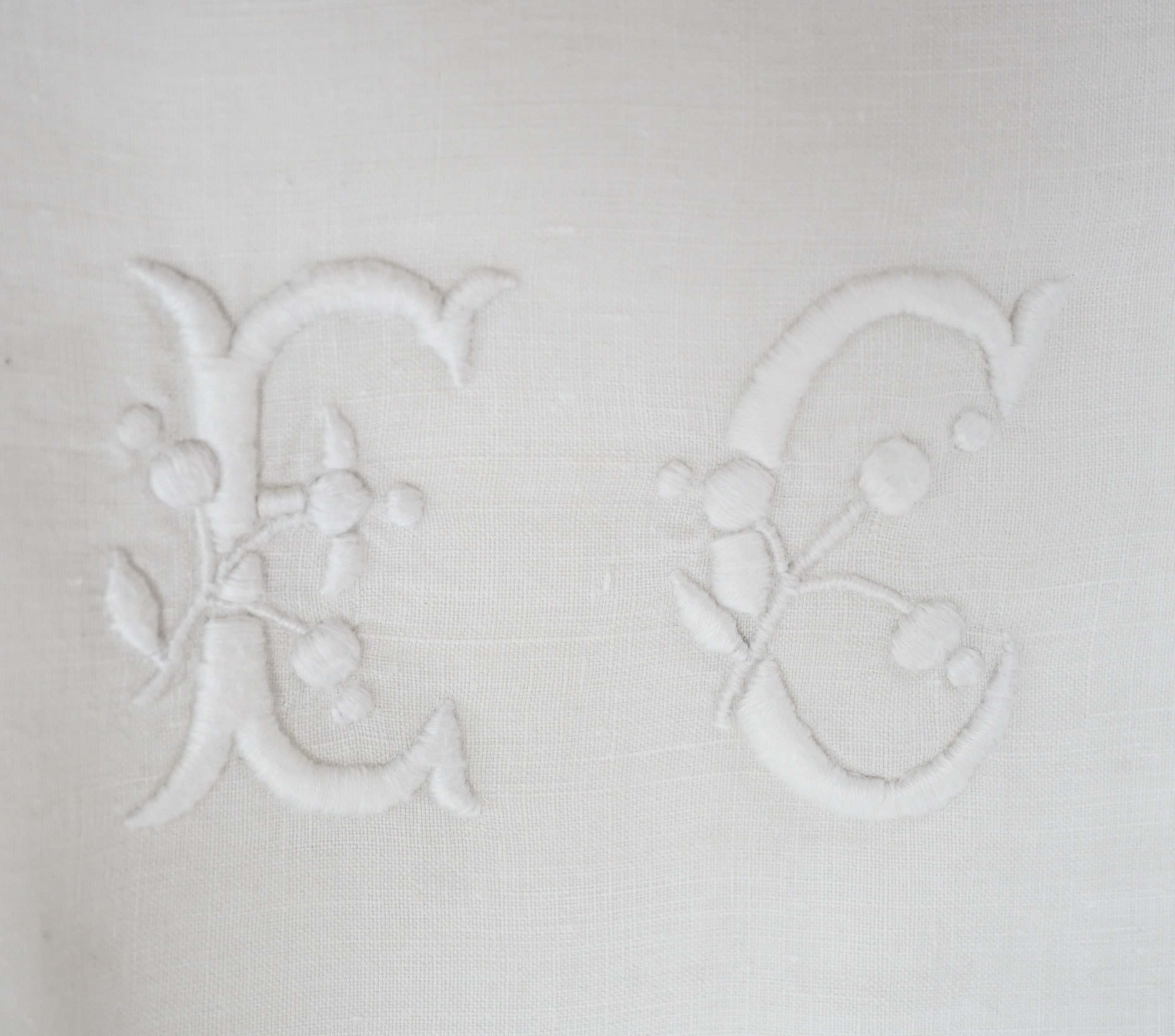 Two large linen white-worked table cloths, a collection of smaller crochet cloths and various sized monogrammed linen napkins, all linen laundered and starched. Condition - good
